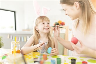 Playful woman with daughter preparing easter