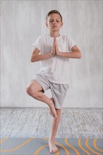 Portrait boy standing yoga pose one leg