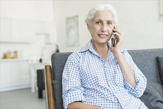 Portrait senior woman talking mobile phone home