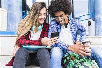 Portrait smiling diverse young students looking mobile phone