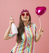 Portrait young woman party with balloon champagne bottle
