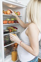 Pregnant woman looking into fridge