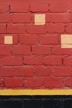 Red brick wall with yellow spots