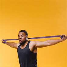 Side view athletic man pulling resistance band