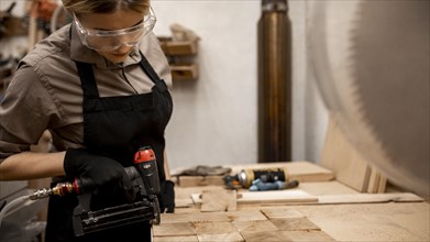 Side view female carpenter with pneumatic stapler