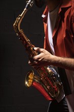 Side view male musician playing saxophone