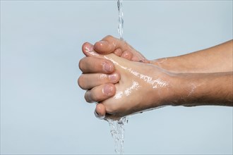 Sideways person washing hands isolated blue