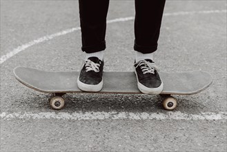 Skater girl legs standing her skateboard