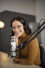 Smiley woman broadcasting radio with headphones microphone