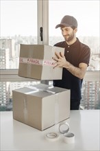 Smiling delivery man holding parcel