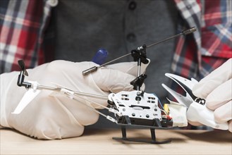 Technician wearing gloves repairing helicopter toy