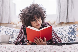 Teenager reading book bed