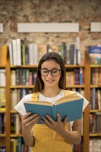 Teenage schoolgirl looking library book