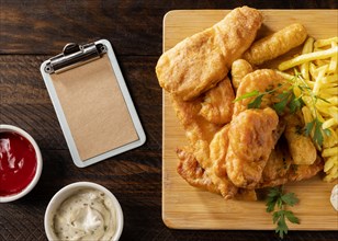 Top view fish chips with clipboard sauces