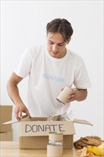 Volunteer placing cans with food boxes