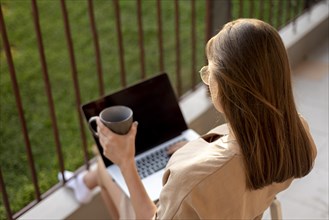 Woman home quarantine working with laptop outdoors