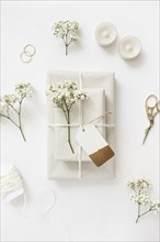 Wrapped gift boxes with baby s breath flowers tag with candles scissor wedding rings