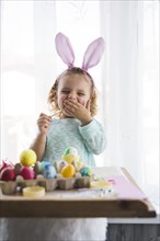 Yawning girl coloring eggs