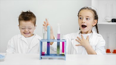 Young child scientists having fun doing experiments laboratory