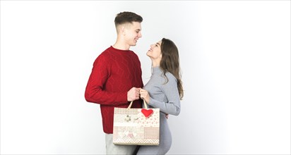 Young couple standing with gift bag