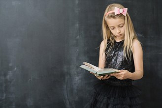 Young girl with book chalkboard