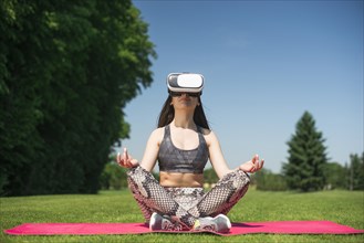 Athletic woman using virtual reality glasses outdoor