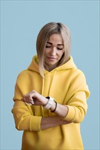 Blonde asian woman looking her smart watch