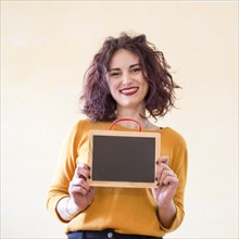 Brunette blogger showing blackboard camera