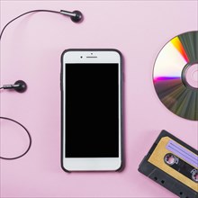 Cellphone with earphone disc cassette pink background