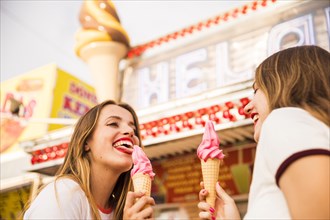 Close up two happy female friends eating ice cream