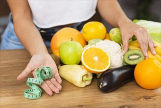 Close up woman with fruits measuring tape