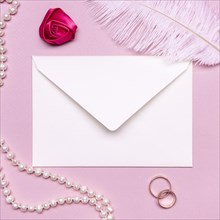 Elegant envelope surrounded by pearls wedding rings