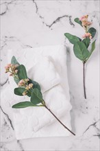 Elevated view pink flowers white napkins marble surface