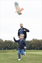 Father son playing with kite front view