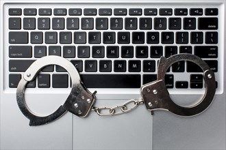 Flat lay laptop with handcuffs
