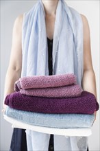 Front view person holding stacked towels