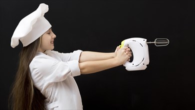 Girl holding electric mixer side view