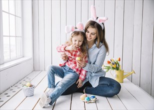 Girl mother bunny ears painting eggs easter