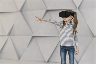 Girl wearing virtual reality headset stretching her hand