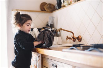 Girl wiping her hand with towel kitchen
