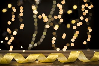 Golden ribbon lying near blurred lights
