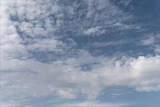 Gradient blue sky with white clouds