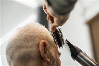 Hairdresser making styling male salon