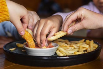 Hands holding french fries close up
