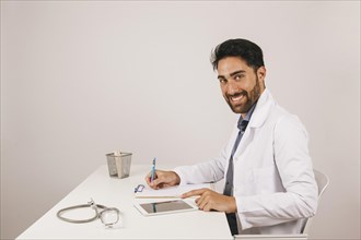 Happy doctor with tablet office