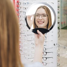 Happy woman looking new glasses optometrist 3