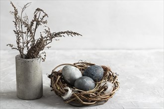 High angle easter eggs bird nest with vase flowers