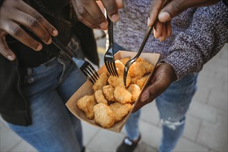 High angle people eating nuggets out takeout packaging
