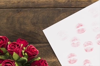 Lipstick kisses paper near beautiful flowers