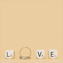 Love letter made with wedding diamond rings cubes cream background